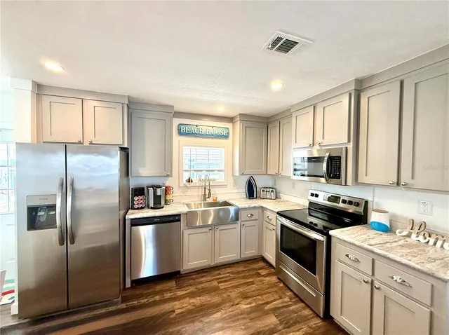 a kitchen with stainless steel appliances a refrigerator sink and cabinets