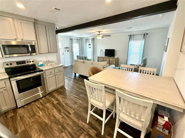 a dining room with a stove a sink and a microwave