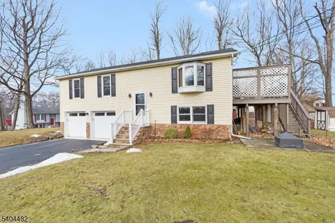 a view of a house with a yard covered in snow