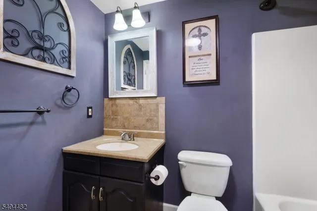 a bathroom with a toilet a sink and mirror