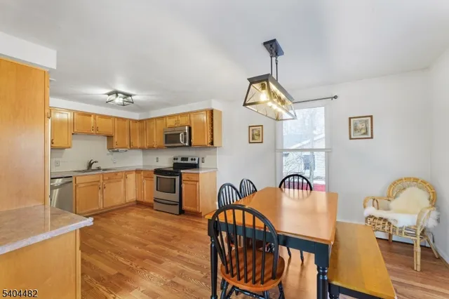 a kitchen that has a lot of white cabinets and stainless steel appliances