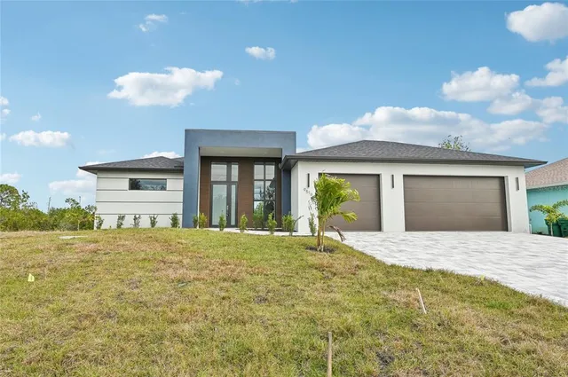 a view of a house with a yard and potted plants