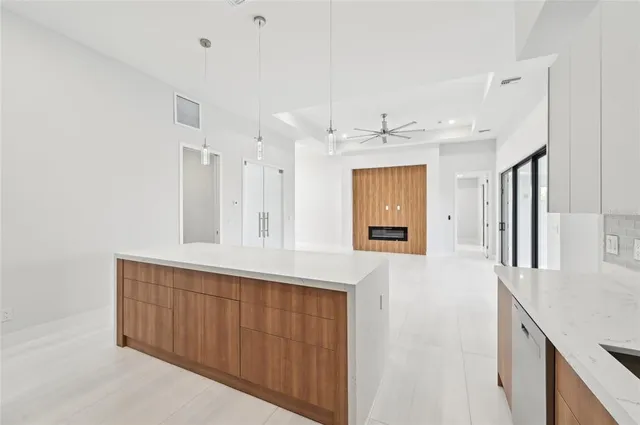 an empty room with large windows and a ceiling fan