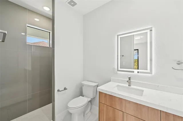 a view of an empty room with wooden floor and windows