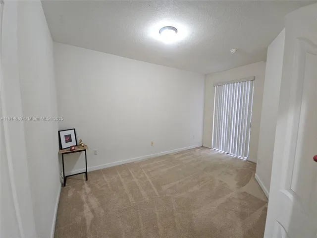 an empty room with windows and wooden door