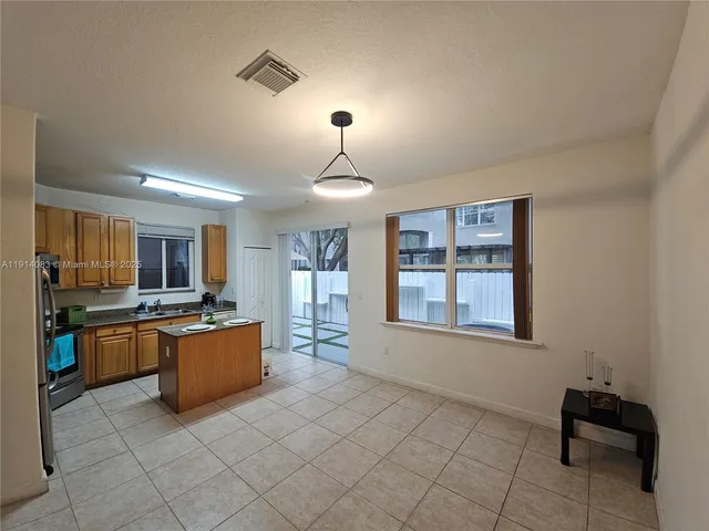 a kitchen with stainless steel appliances granite countertop a refrigerator a stove a sink dishwasher and a refrigerator with wooden floor