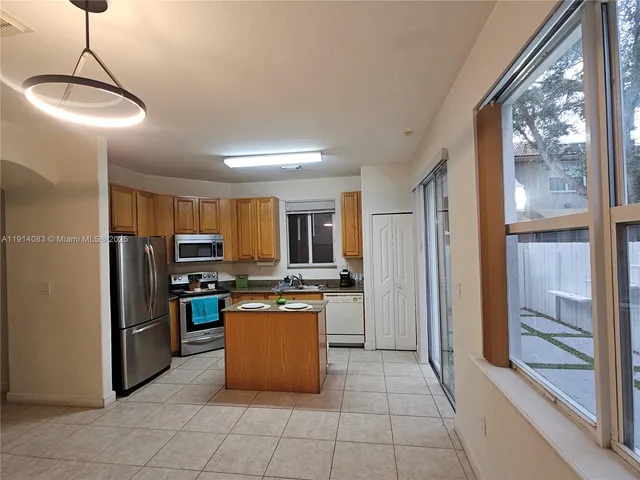 a kitchen with kitchen island a sink stove and refrigerator