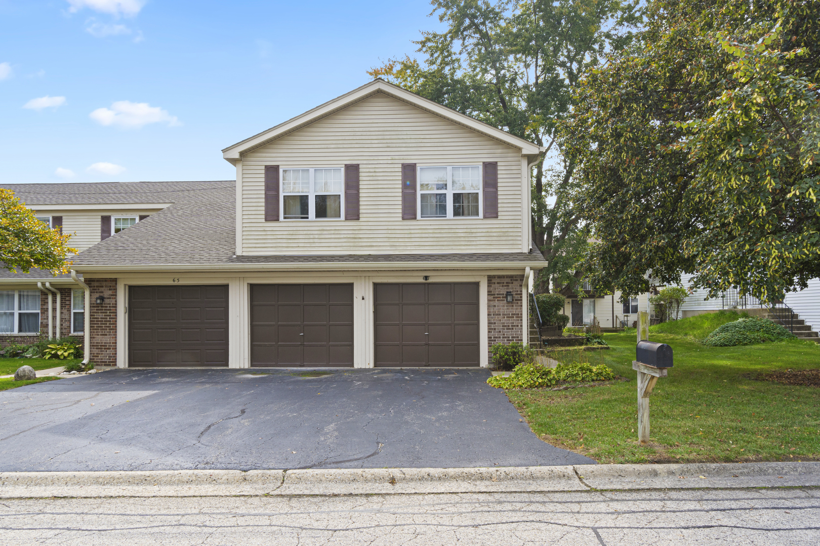 a front view of a house with a yard and trees
