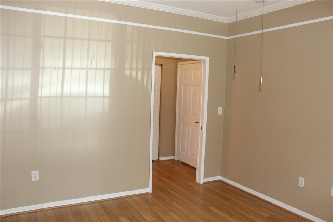 520 Florida Club Boulevard, Unit 103 St. Augustine, FL 32084 - Photo 15 of 26 an empty room with wooden floor and windows