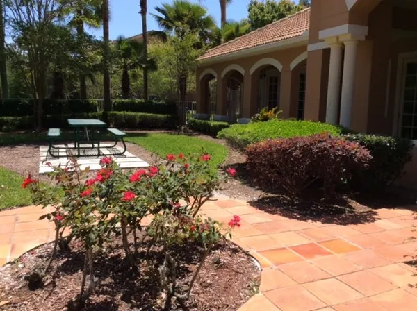 a view of a patio with table and chairs with plants and wooden fence