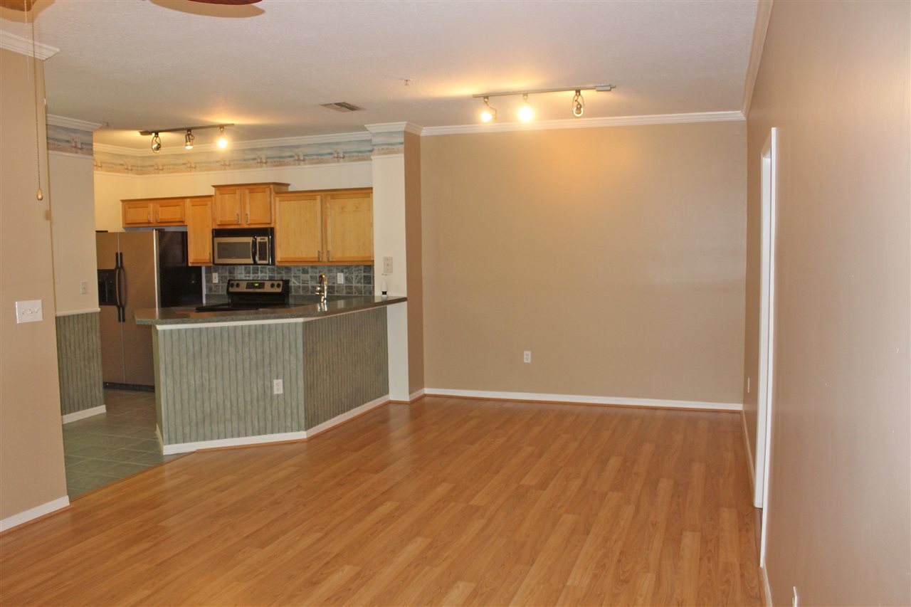 520 Florida Club Boulevard, Unit 103 St. Augustine, FL 32084 - Photo 3 of 26 a view of a room with wooden floor and kitchen