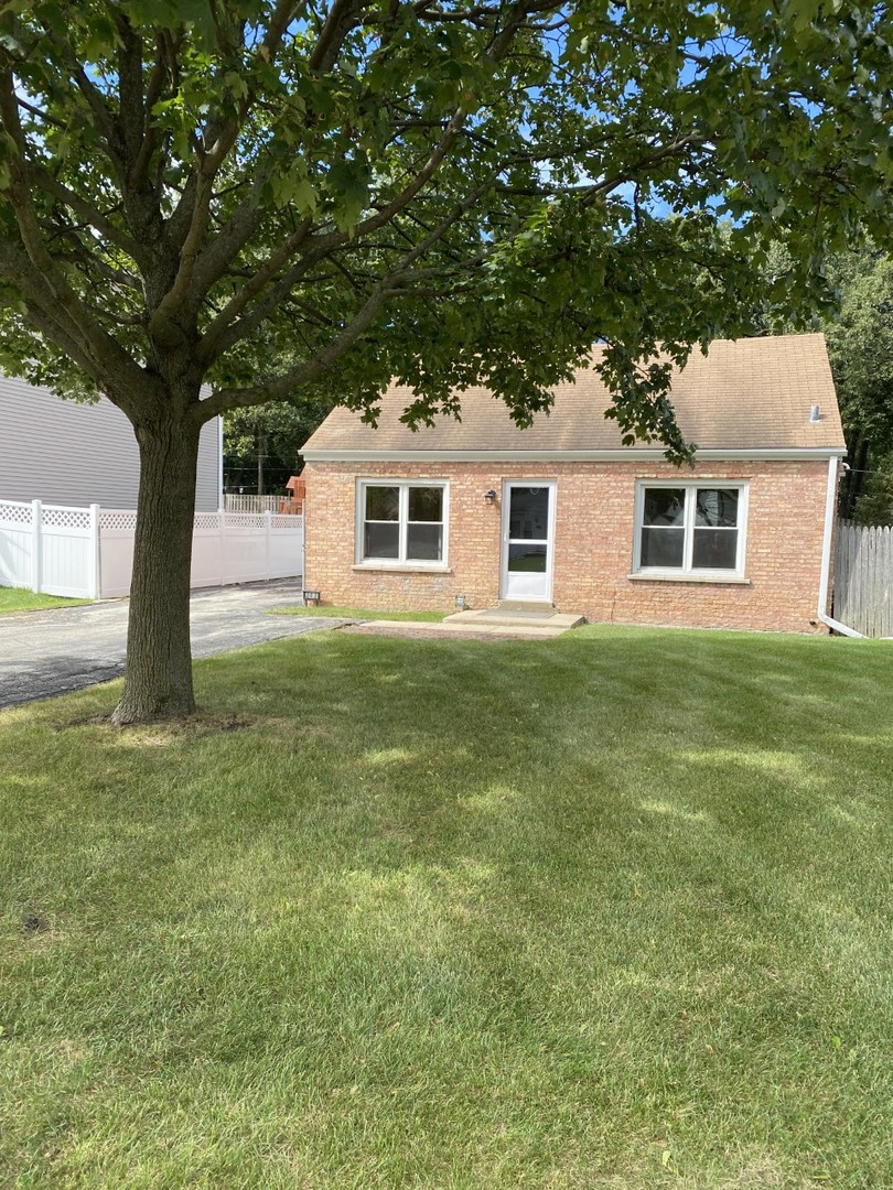 a house that has a tree in front of a white house
