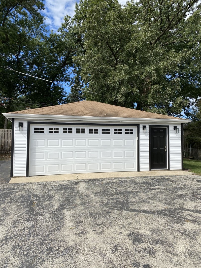 242 Highland Road Willowbrook, IL 60527 - Photo 2 of 24 a front view of a house with a yard and garage