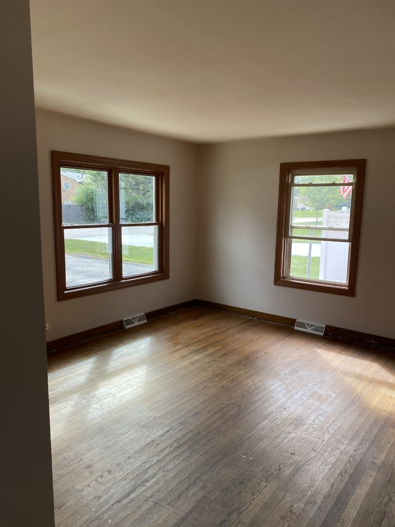 242 Highland Road Willowbrook, IL 60527 - Photo 7 of 24 an empty room with wooden floor and windows