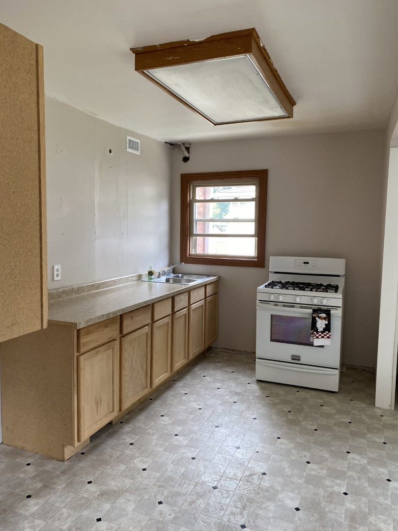 242 Highland Road Willowbrook, IL 60527 - Photo 10 of 24 a kitchen with stainless steel appliances a stove and white cabinets