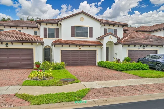 a front view of a house with a garden and plants