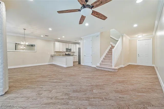 a view of empty room with wooden floor and ceiling fan