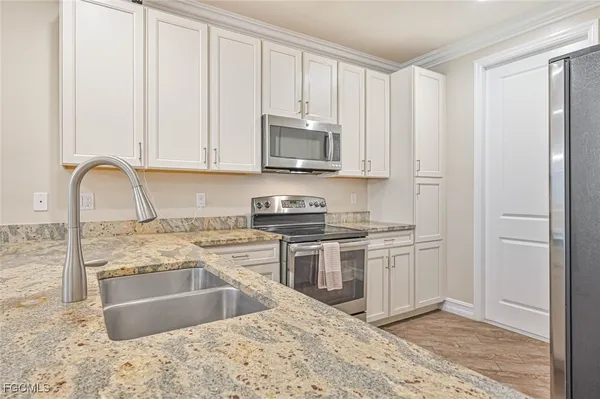 a kitchen with stainless steel appliances granite countertop a stove a sink and a microwave