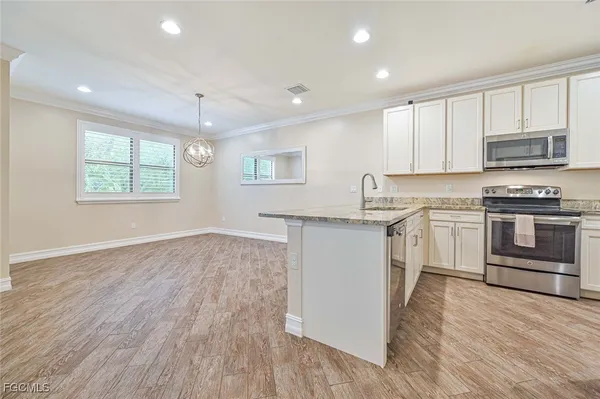 a kitchen with granite countertop a stove top oven and cabinets