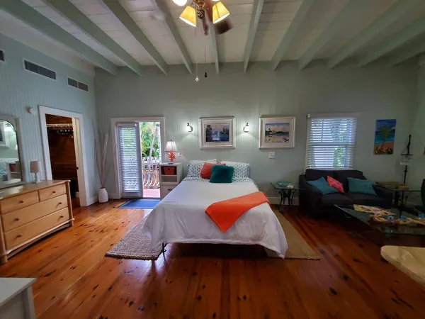 a bedroom with furniture and a wooden floor