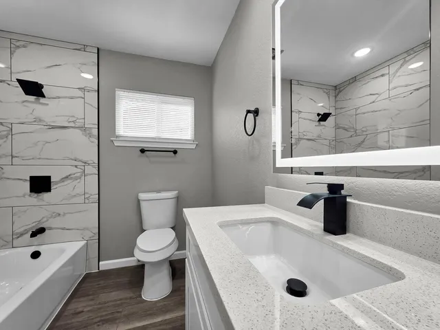 a bathroom with a double vanity sink mirror and toilet