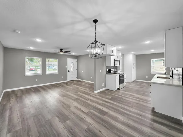 a view of a kitchen with kitchen island wooden floor center island and windows