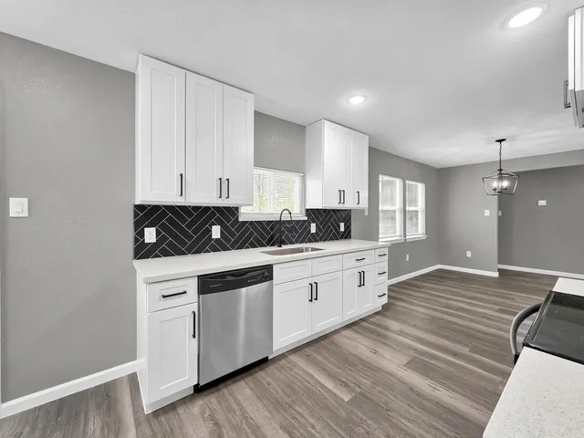 a kitchen with granite countertop white cabinets and white appliances