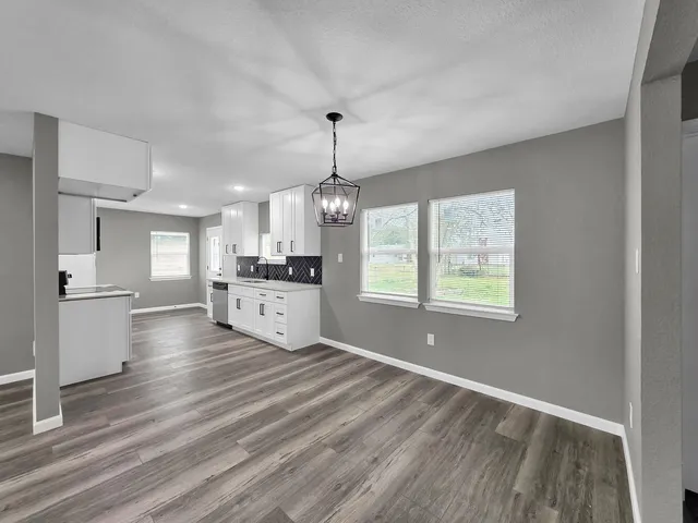 a view of an empty room with closet and a window
