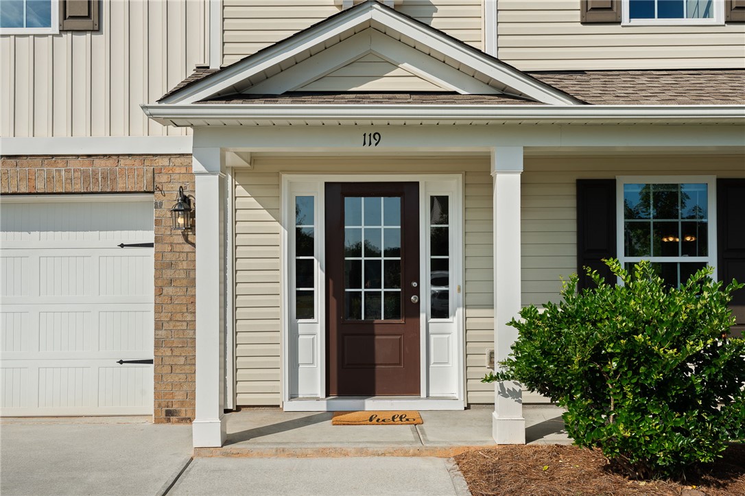 119 Sunny Point Loop Central, SC 29630 - Photo 2 of 33 A welcoming front porch features classic columns, clean siding, and a paneled entry door.