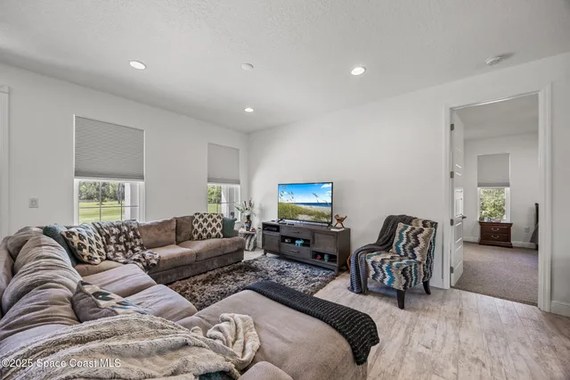 a living room with furniture and view of kitchen