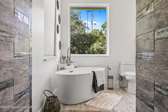 a bathroom with a wooden floor and a shower