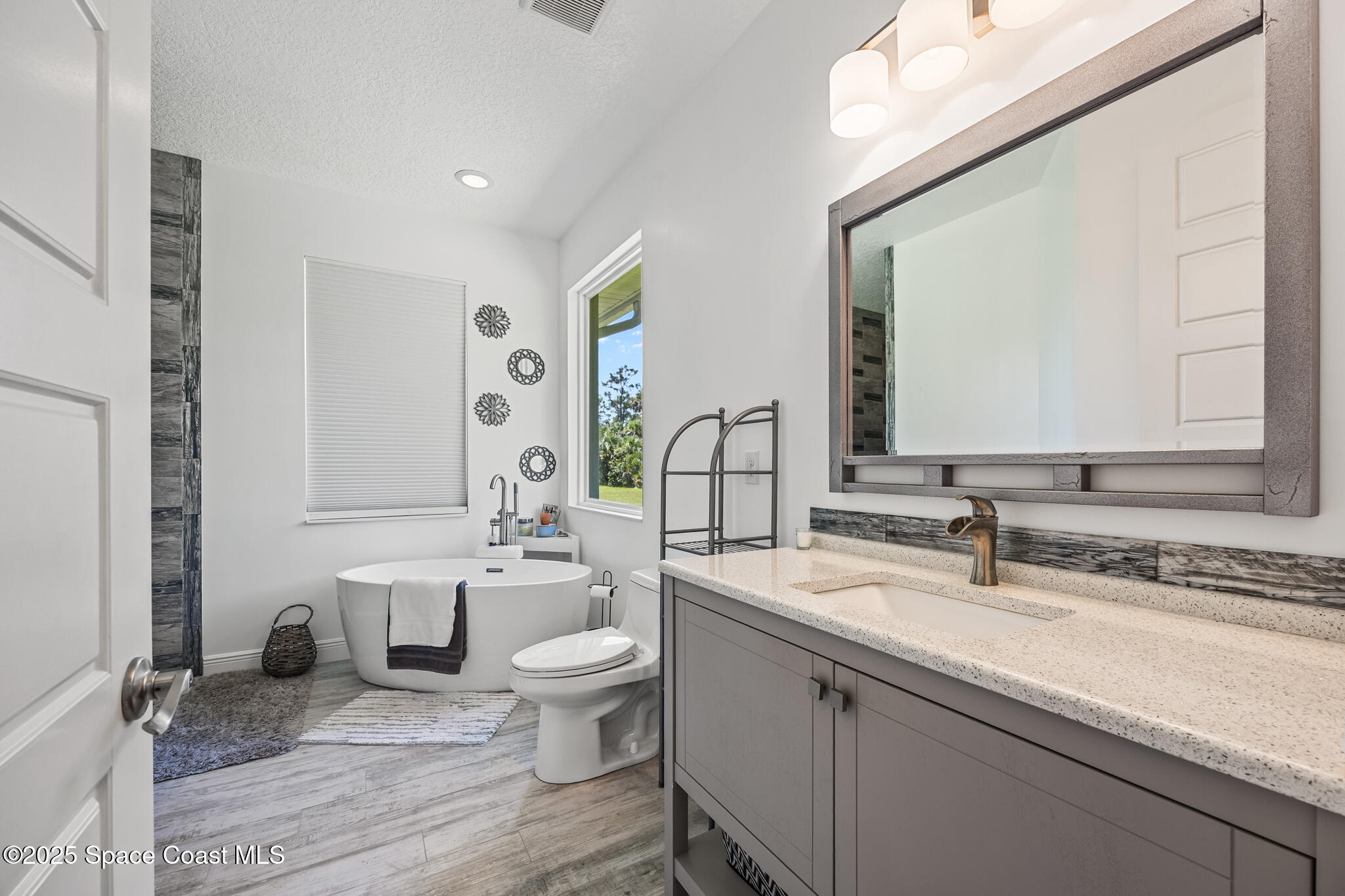 2050 Valkaria Road Grant-Valkaria, FL 32950 - Photo 20 of 56 a bathroom with a granite countertop sink and a mirror