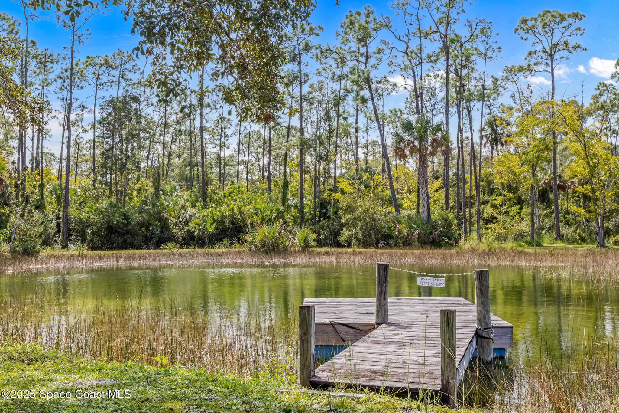 2050 Valkaria Road Grant-Valkaria, FL 32950 - Photo 39 of 56 a wooden bench sitting next to a lake