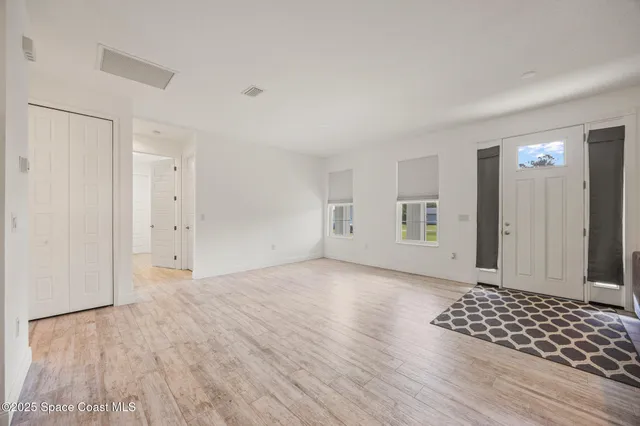 an empty room with wooden floor and white walls