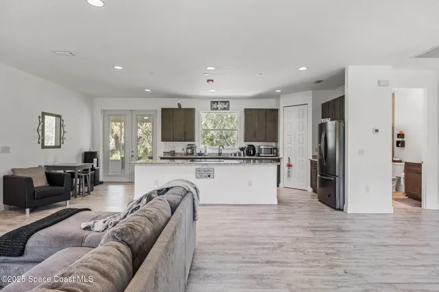 a living room with kitchen island furniture and a kitchen view