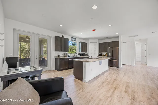 a large white kitchen with a large window and stainless steel appliances