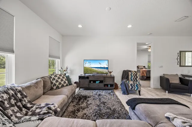 a living room with furniture couches and a flat screen tv