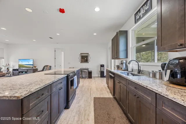 a large kitchen with kitchen island granite countertop a sink and dishwasher stove top oven with granite countertops