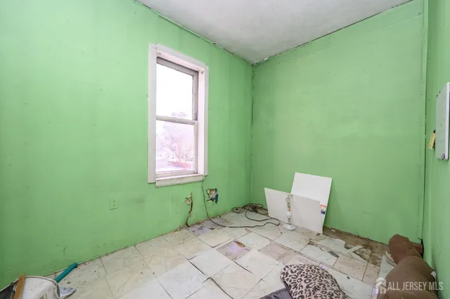a view of a white house with a large windows and lawn chairs under an umbrella