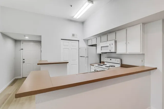 a kitchen with stainless steel appliances granite countertop a sink refrigerator and white cabinets