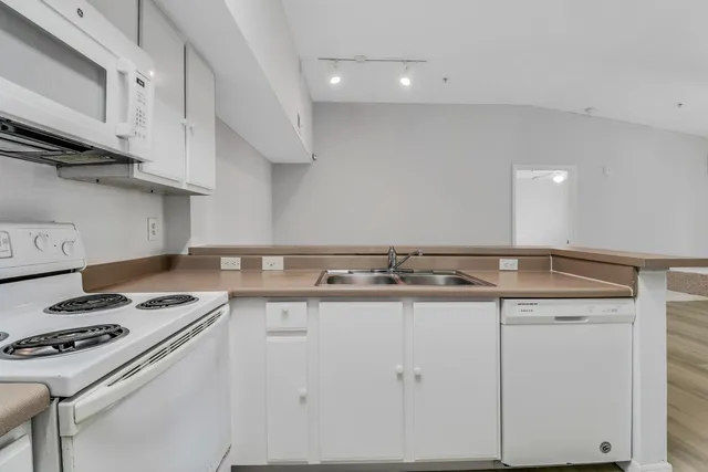 a kitchen with granite countertop a sink stove and cabinets