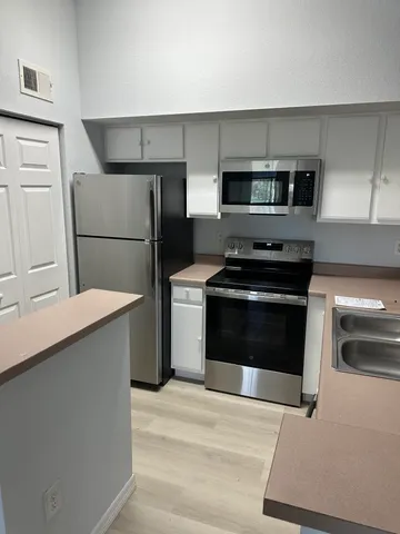 a kitchen with stainless steel appliances a stove a microwave and a refrigerator