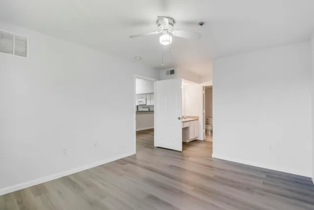 a view of a kitchen with wooden floor and a ceiling fan