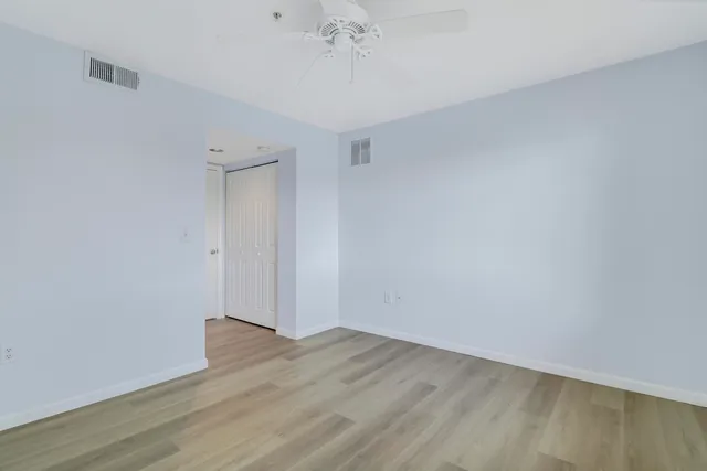 a view of a room with wooden floor and a ceiling fan