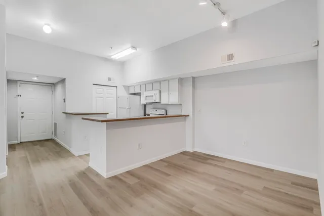 a kitchen with granite countertop white cabinets and wooden floor