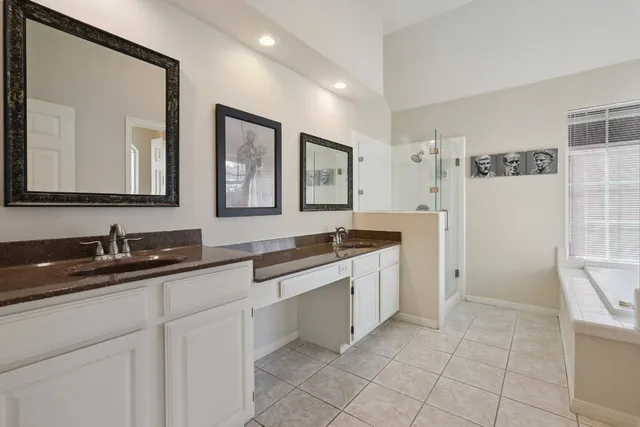 a spacious bathroom with a granite countertop sink a mirror and a