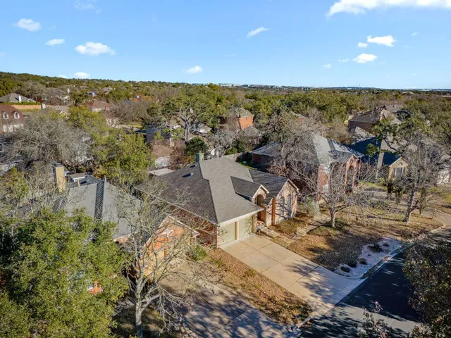 an aerial view of residential houses with outdoor space and trees