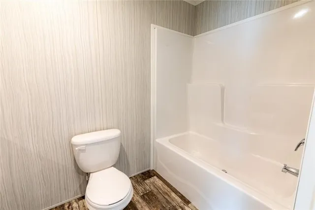 a white toilet sitting next to a white tub