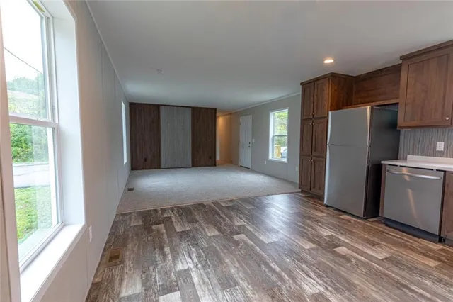 a view of a kitchen with refrigerator and wooden floor