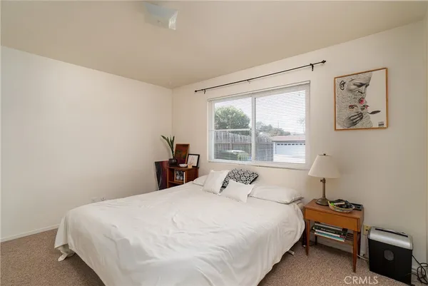 a large bed sitting in a bedroom next to a window